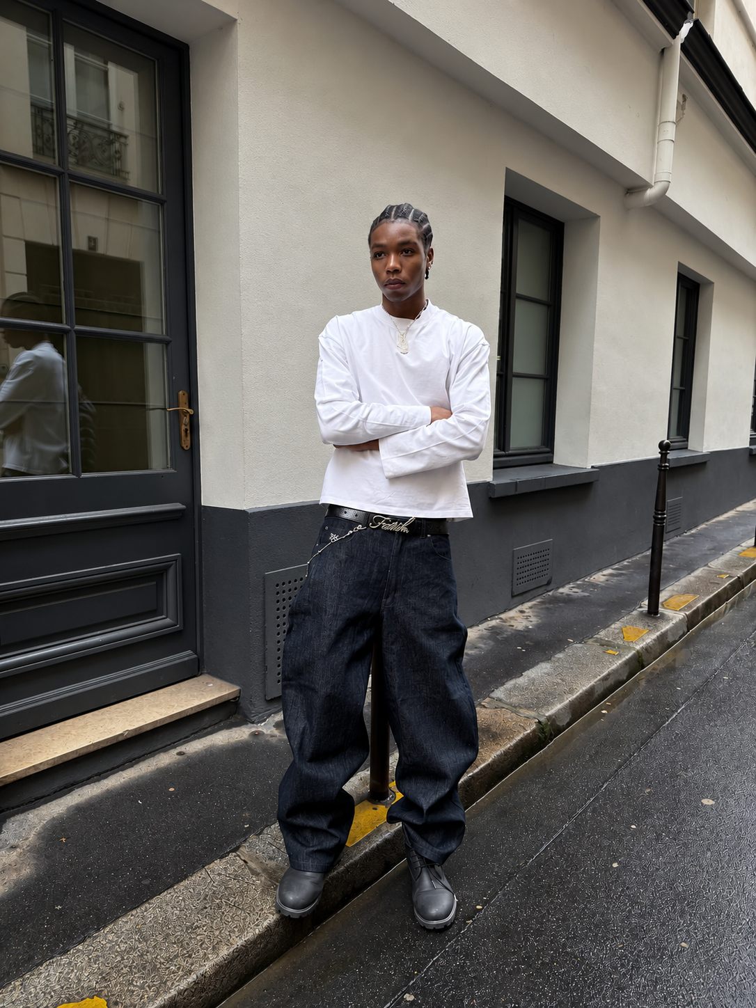 A man in a reda studio white longsleeve and raw denim jeans on a Paris street